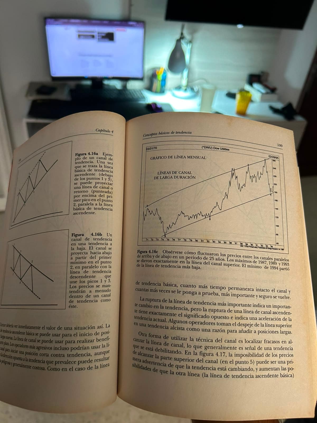 Un libro de análisis técnico abierto en el capítulo de canales de tendencia, sobre el escritorio de Gabriel